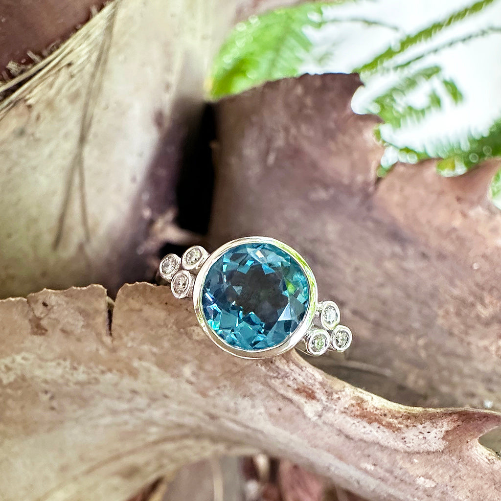 Delicately Bezel Set Blue Topaz with Trilogy Shoulder Diamond Highlight White Gold Ring