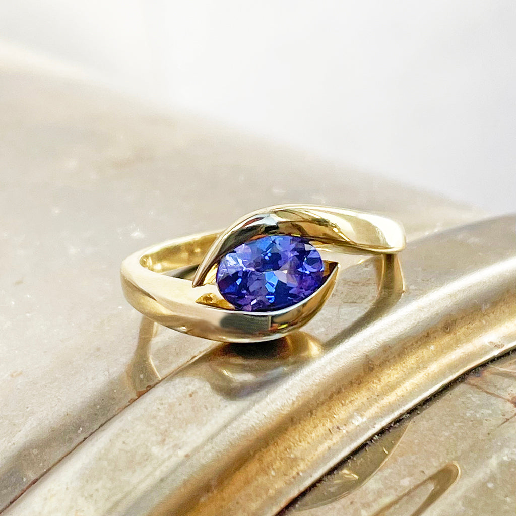 Gently Embraced Oval Tanzanite Yellow Gold Ring