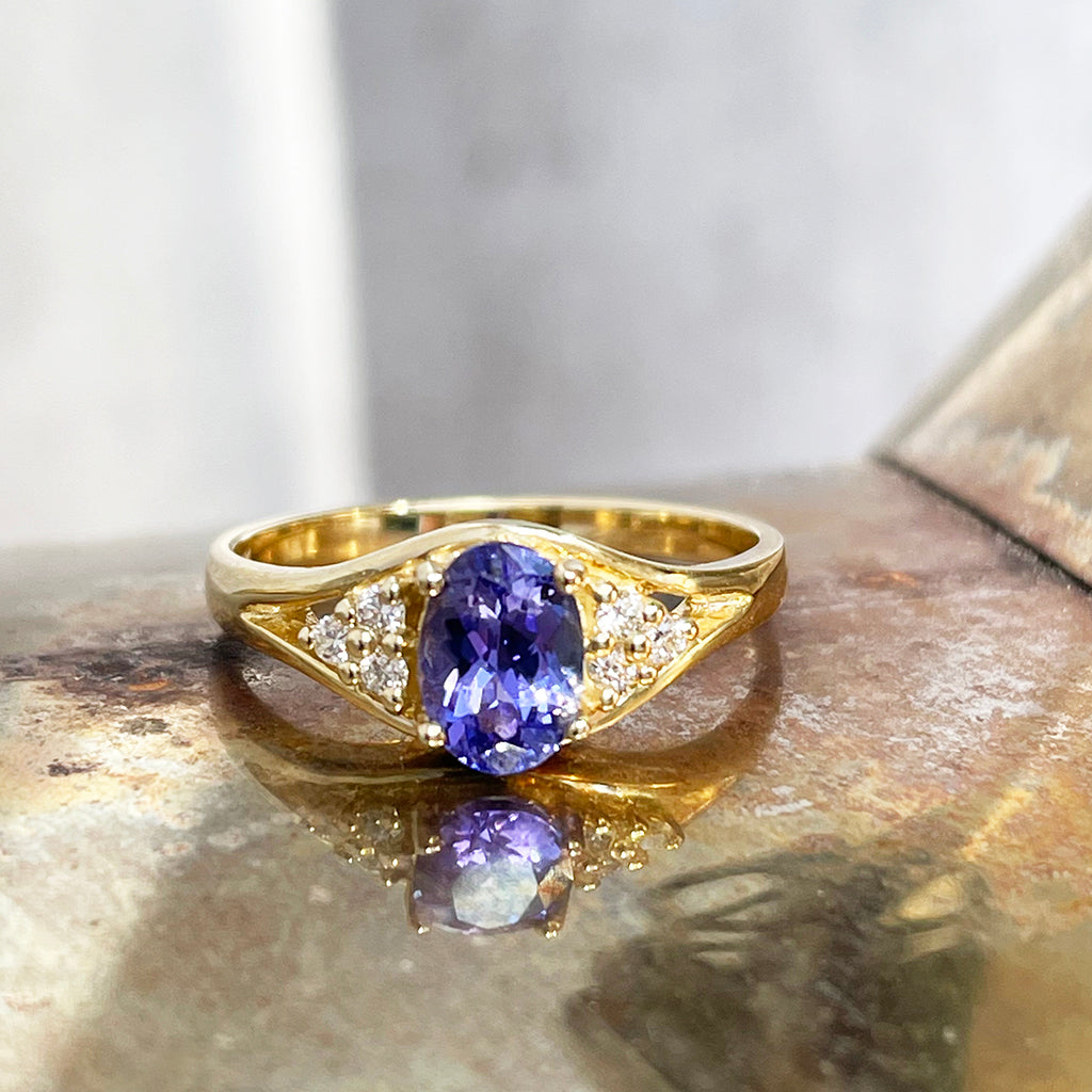 Regal Oval Tanzanite and Trilogy Diamond Shouldered Yellow Gold