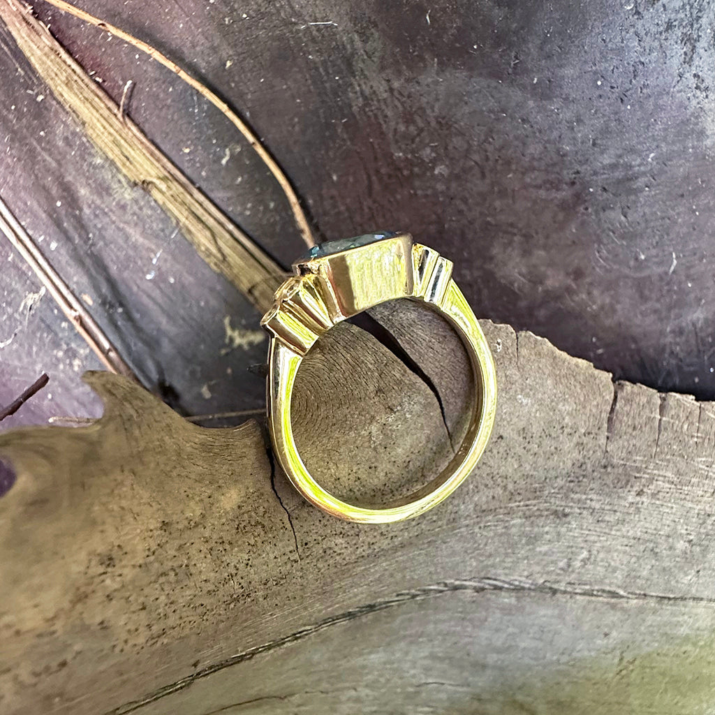 Delicately Bezel Set Blue Topaz with Trilogy Shoulder Diamond Highlight Yellow Gold Ring
