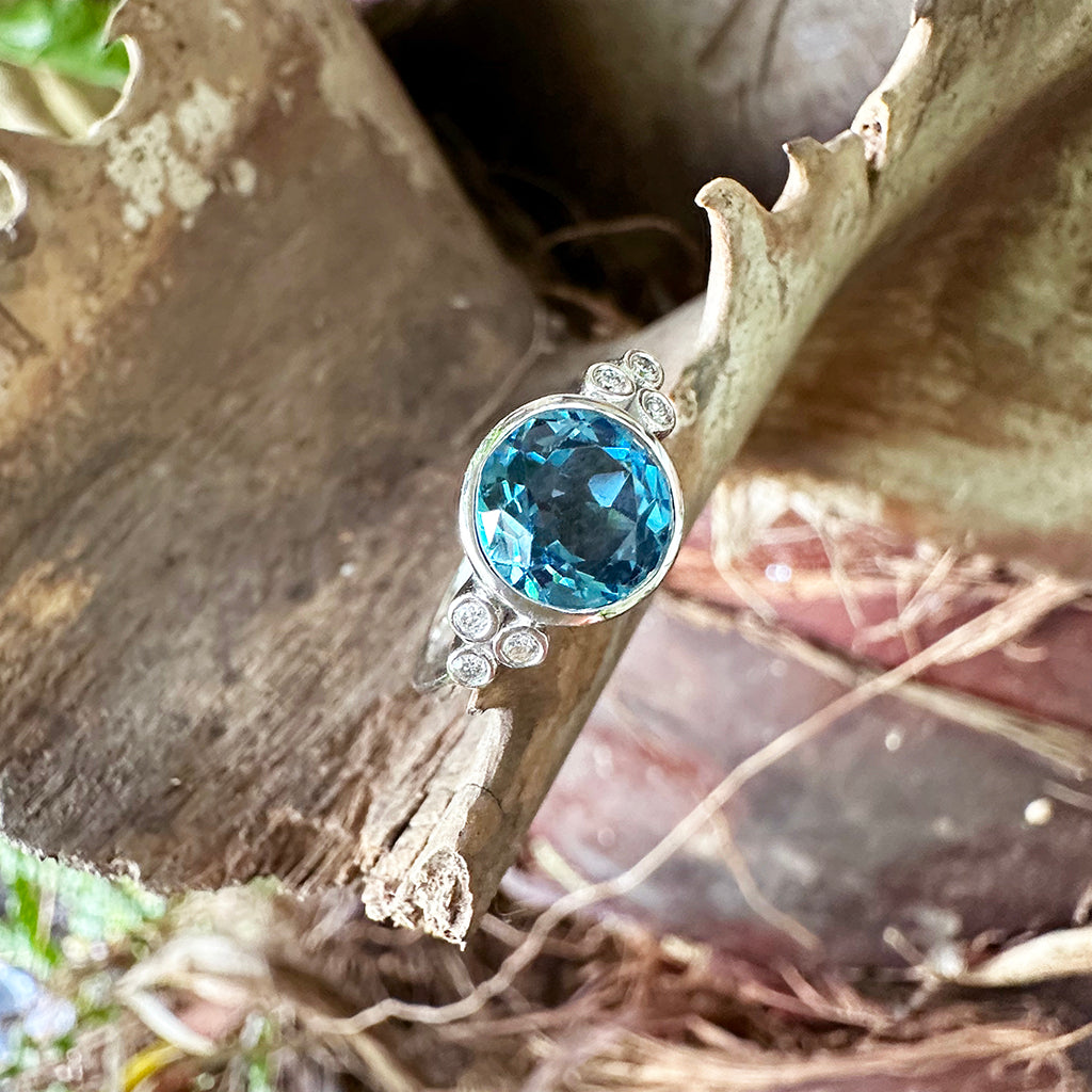 Delicately Bezel Set Blue Topaz with Trilogy Shoulder Diamond Highlight White Gold Ring