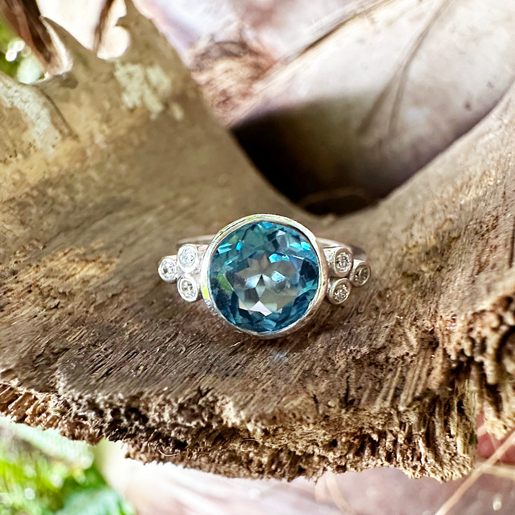 Delicately Bezel Set Blue Topaz with Trilogy Shoulder Diamond Highlight White Gold Ring