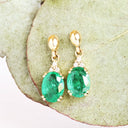 Elegant Oval Cut Emerald and Trilogy Diamond Drop Earrings In Yellow Gold