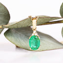 Elegant Oval Cut Emerald and Trilogy Diamond Pendant In Yellow Gold
