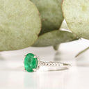 Elevated Four Claw Emerald Ring With Diamond Shoulders In White Gold
