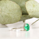 Elevated Four Claw Emerald Ring With Diamond Shoulders In White Gold