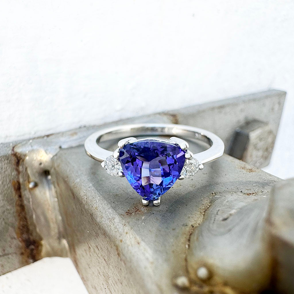 White Gold Double Claw Trilliant Cut Tanzanite With Diamond Shoulder Highlight Ring