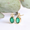 Sublime Bezel Set Oval Cut Emerald and Trilogy Diamond Earrings In Yellow Gold