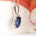Oval Sapphire and Diamond Halo Pendant in white Gold