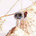 Oval Cut Black diamond ring with white diamond halo