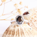 Oval Cut Black diamond ring with white diamond halo