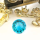 Blue gemstone with gold jewelry components on a white background