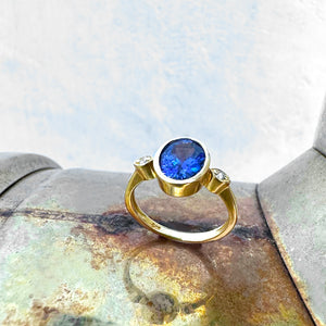 Elegant Oval Bezel Set Tanzanite with Petite Diamond Highlight Yellow Gold Ring