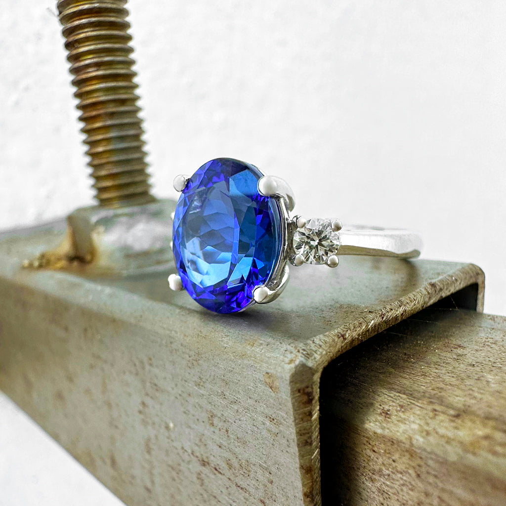 Elevated Four Claw Oval Cut Tanzanite and Diamond Highlight White Gold Ring