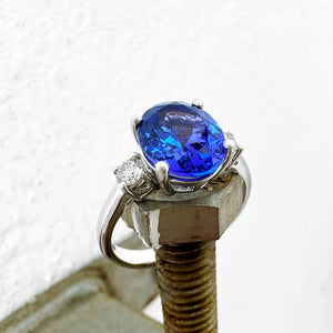 Elevated Four Claw Oval Cut Tanzanite and Diamond Highlight White Gold Ring