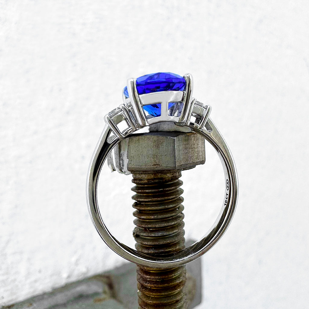 Elevated Four Claw Oval Cut Tanzanite and Diamond Highlight White Gold Ring