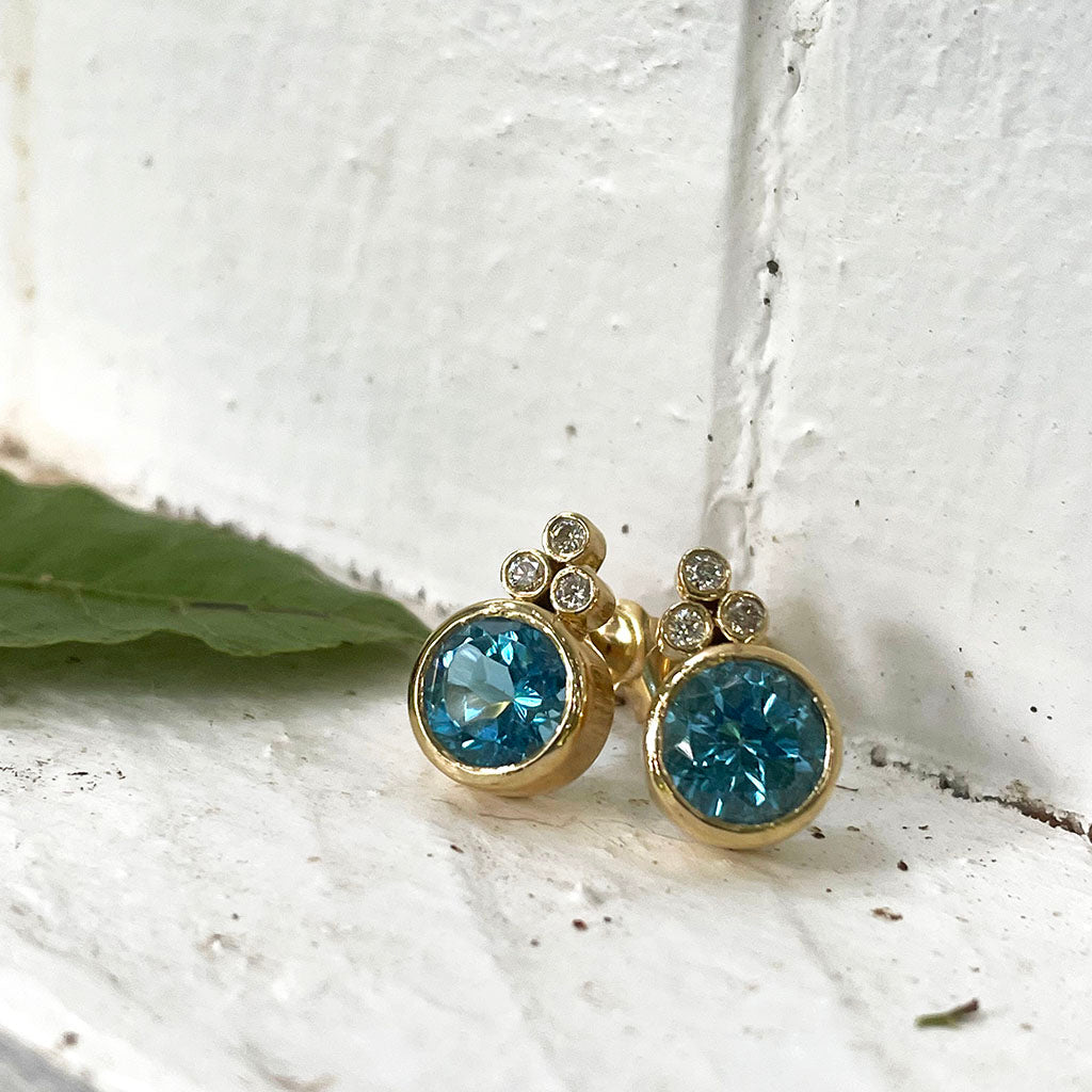 Bezel Set Blue Topaz Earrings With Trilogy Diamond Accent