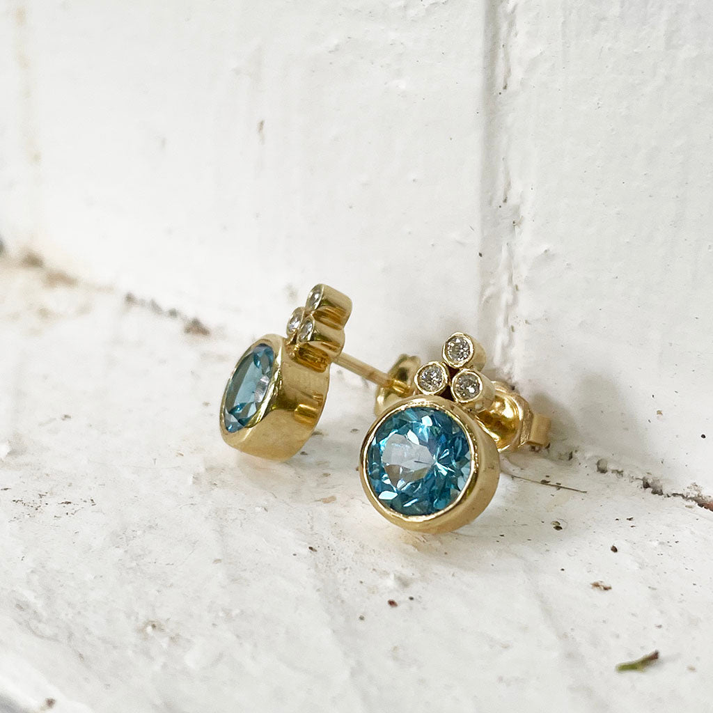 Bezel Set Blue Topaz Earrings With Trilogy Diamond Accent