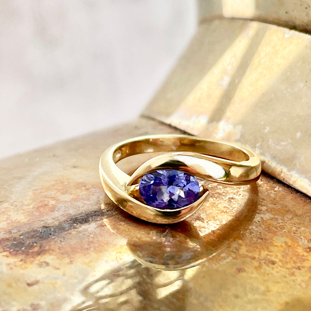 Gently Embraced Oval Tanzanite Yellow Gold Ring