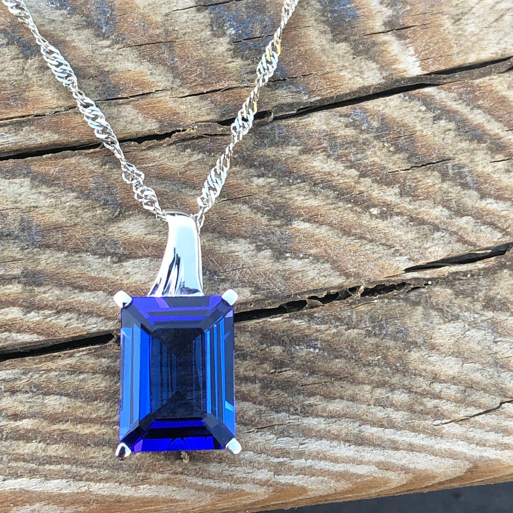 Emerald Cut Tanzanite with Swish Detailed Fixed Bale pendant