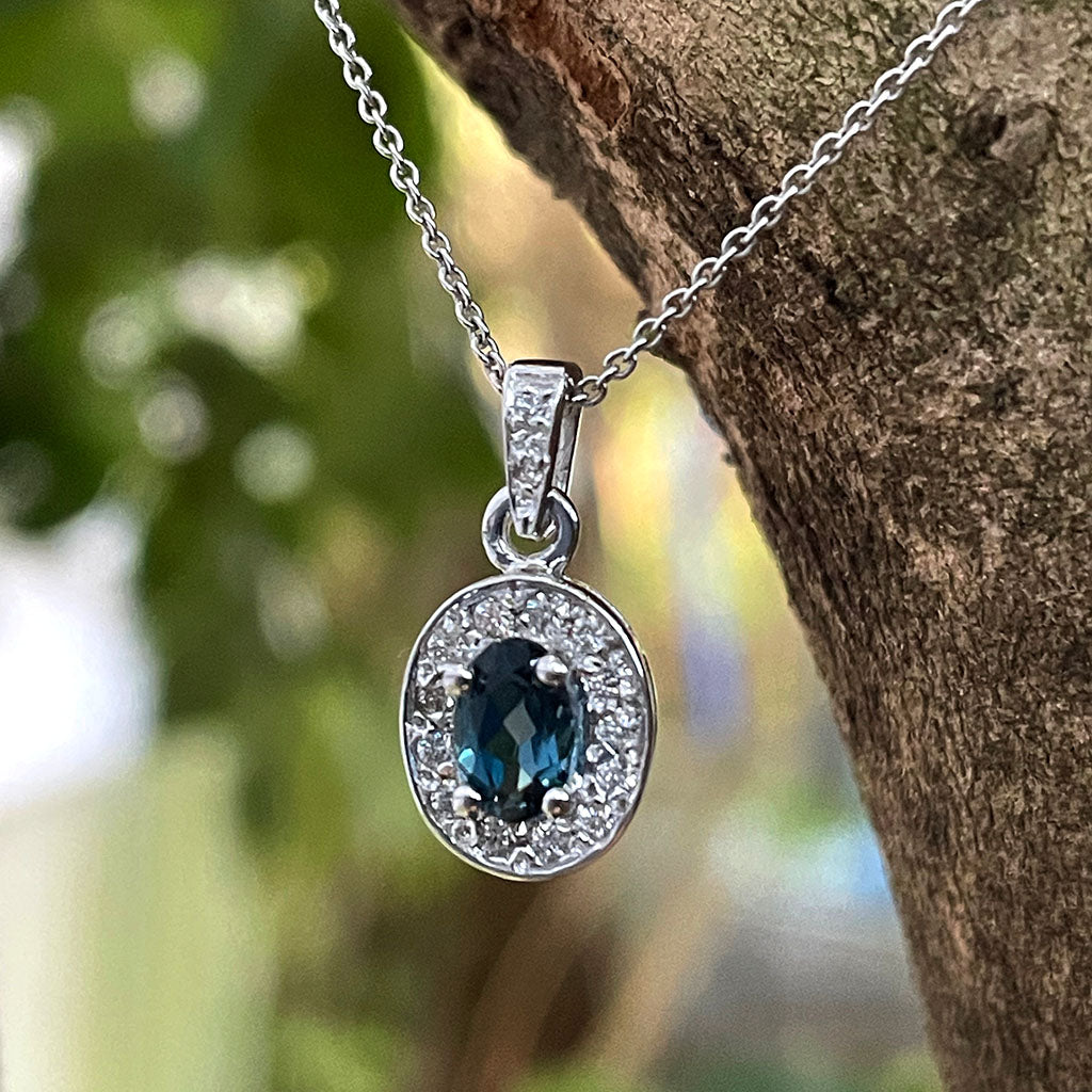 Oval London Blue Topaz And White Gold Diamond Halo Pendant