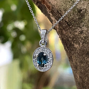 Oval London Blue Topaz And White Gold Diamond Halo Pendant