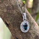 Oval London Blue Topaz And White Gold Diamond Halo Pendant