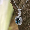 Oval London Blue Topaz And White Gold Diamond Halo Pendant