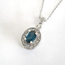 Oval London Blue Topaz And White Gold Diamond Halo Pendant
