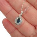 Oval London Blue Topaz And White Gold Diamond Halo Pendant