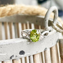 Oval Peridot With Twisted Shoulders And Diamond Highlight Ring